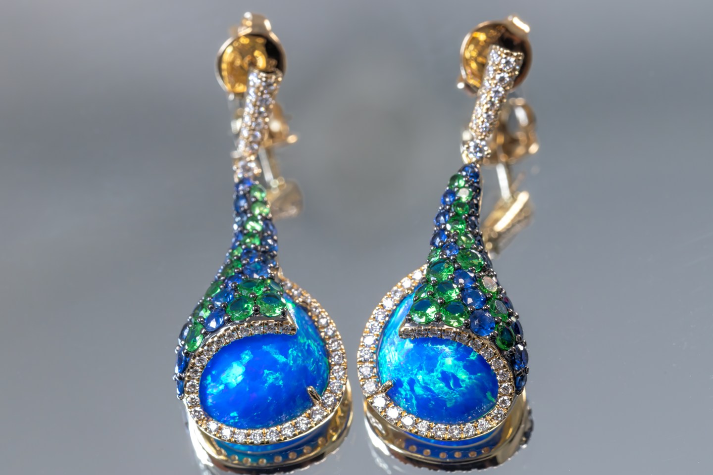 14K yellow gold earrings set with opal, sapphires, diamonds, and tsavorites from the Melissani Collection